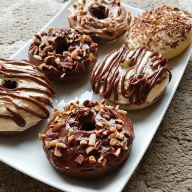 Made keto donuts with cream cheese and chocolate frosting, topped with roasted pecans. The BEST low carb keto donuts recipe EVER! Keto recipes really don’t get better than these almond flour cinnamon sugar donuts. These donuts make a great keto breakfast idea, or dessert idea, and are just so easy to make. Plus, each donut is super low carb! They ONLY HAVE 2 NET CARBS a piece! This recipe makes 6 donuts (3 inches in diameter). INGREDIENTS For Donuts • 1 & 1/4 Cups Almond Flour • 1/2 Cup Erythritol • 1 Tsp Baking Powder • 1/4 Tsp Salt • 1 & 1/2 Tbsp Unsalted Butter (Melted) • 2 Tbsp Milk (any milk of your choice, in this case I used almond milk) • 2 Large Eggs • 1 Tsp Vanilla Extract For Cream Cheese Frosting: • 80 grams Cream Cheese • 2 Tbsp Heavy Cream • 3 Tbsp Erythritol • 1/2 Tsp Vanilla Extract For Chocolate Ganache: • 40 grams 90% Lindt Cocoa • 3 Tbsp Heavy Cream • 2 Tbsp Erythritol • 1/2 Tsp Vanilla Extract INSTRUCTIONS For Donuts • Preheat over to 350f/176c. • In a large bowl, mix all the dry ingredients together: almond flour, erythritol, baking powder and salt. • In a separate bowl, melt unsalted butter and whisk in almond milk, two large eggs and vanilla extract. • Combine the wet ingredients into the large bowl of dry ingredients. Mix until a thicker batter is formed. • Spray a donut tray with non-stick cooking spray. Add in the batter, only filling 3/4 of each donut ring. • Bake at 350f/176c for 15 mins. For Cream Cheese Frosting: • Mix cream cheese and heavy cream until softened and smooth. • Add vanilla extract and erythritol to your desired taste. For Chocolate Ganache: • Melt 90% cocoa and add in heavy cream. • Mix until smooth and well incorporated. • Add vanilla extract and erythritol to your desired taste. Optional: Pecans (I used Organic Roasted Pecan Nuts) NUTRITION FACTS Include Frosting: Calories: 197 | Fat: 18.2 | Protein: 6.8 | Net Carb: 2.2g
