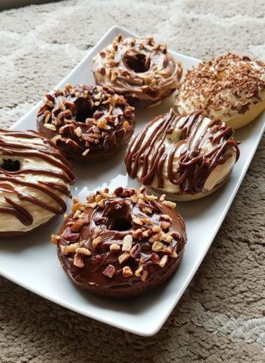 Made keto donuts with cream cheese and chocolate frosting, topped with roasted pecans. The BEST low carb keto donuts recipe EVER! Keto recipes really don’t get better than these almond flour cinnamon sugar donuts. These donuts make a great keto breakfast idea, or dessert idea, and are just so easy to make. Plus, each donut is super low carb! They ONLY HAVE 2 NET CARBS a piece! This recipe makes 6 donuts (3 inches in diameter). INGREDIENTS For Donuts • 1 & 1/4 Cups Almond Flour • 1/2 Cup Erythritol • 1 Tsp Baking Powder • 1/4 Tsp Salt • 1 & 1/2 Tbsp Unsalted Butter (Melted) • 2 Tbsp Milk (any milk of your choice, in this case I used almond milk) • 2 Large Eggs • 1 Tsp Vanilla Extract For Cream Cheese Frosting: • 80 grams Cream Cheese • 2 Tbsp Heavy Cream • 3 Tbsp Erythritol • 1/2 Tsp Vanilla Extract For Chocolate Ganache: • 40 grams 90% Lindt Cocoa • 3 Tbsp Heavy Cream • 2 Tbsp Erythritol • 1/2 Tsp Vanilla Extract INSTRUCTIONS For Donuts • Preheat over to 350f/176c. • In a large bowl, mix all the dry ingredients together: almond flour, erythritol, baking powder and salt. • In a separate bowl, melt unsalted butter and whisk in almond milk, two large eggs and vanilla extract. • Combine the wet ingredients into the large bowl of dry ingredients. Mix until a thicker batter is formed. • Spray a donut tray with non-stick cooking spray. Add in the batter, only filling 3/4 of each donut ring. • Bake at 350f/176c for 15 mins. For Cream Cheese Frosting: • Mix cream cheese and heavy cream until softened and smooth. • Add vanilla extract and erythritol to your desired taste. For Chocolate Ganache: • Melt 90% cocoa and add in heavy cream. • Mix until smooth and well incorporated. • Add vanilla extract and erythritol to your desired taste. Optional: Pecans (I used Organic Roasted Pecan Nuts) NUTRITION FACTS Include Frosting: Calories: 197 | Fat: 18.2 | Protein: 6.8 | Net Carb: 2.2g